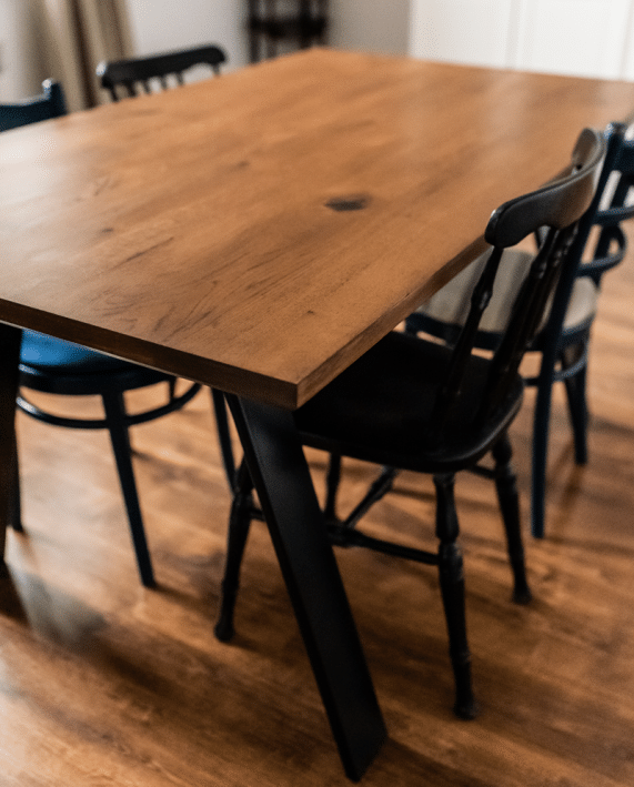 Stół Light Industrial w pomieszczeniu z krzesłami zbliżenie na róg