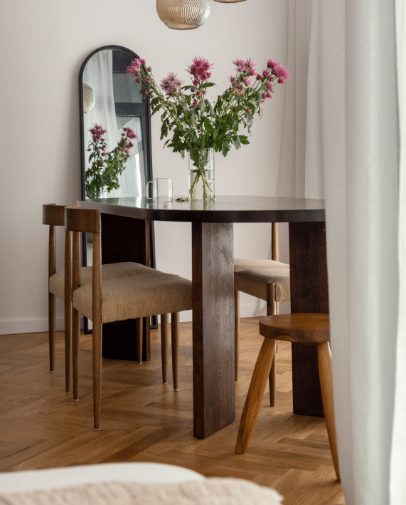 Stół Viktor w pomieszczeniu z krzesłami, lampą i kwiatami
